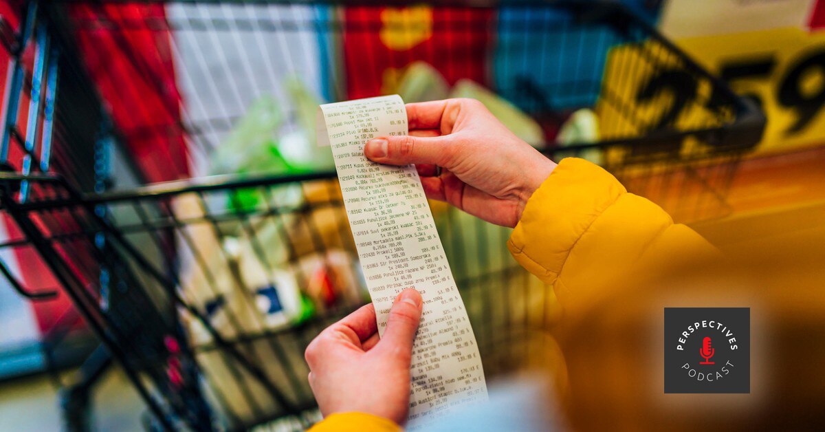 hands holding receipt over a grocery cart